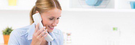junge fröhliche Frau am Telefon